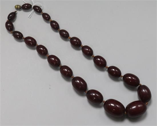 A single strand graduated simulated cherry amber bead necklace, 61cm.